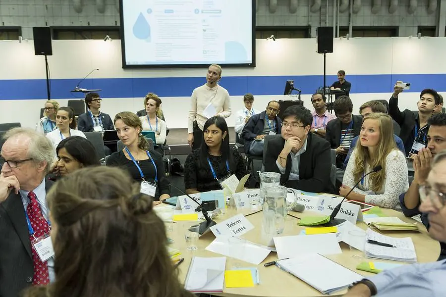 Personas de distintas edades debaten alrededor de una mesa en un encuentro internacional